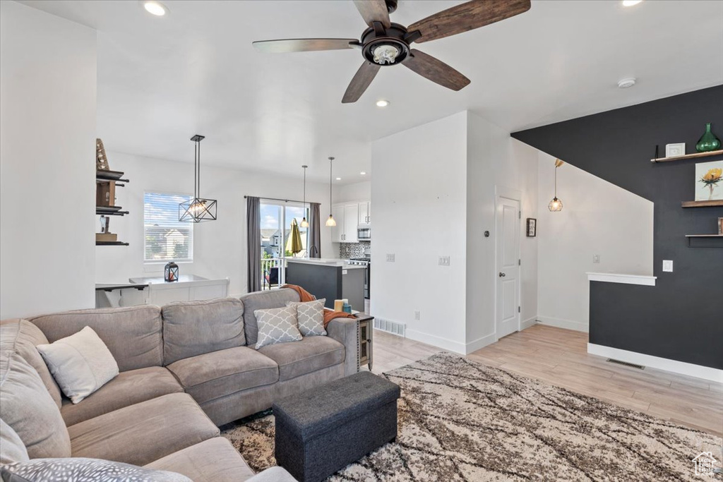 Living room with recessed lighting, light wood-style flooring, and a ceiling fan