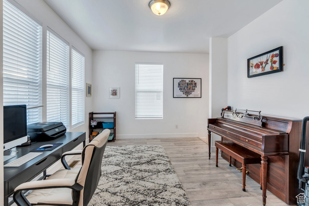 Office with baseboards and light wood-type flooring
