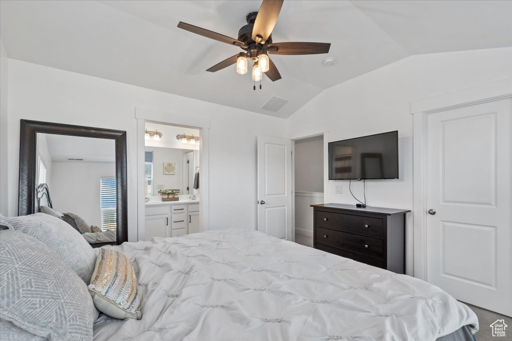 Bedroom with lofted ceiling, ensuite bath, a ceiling fan, and carpet