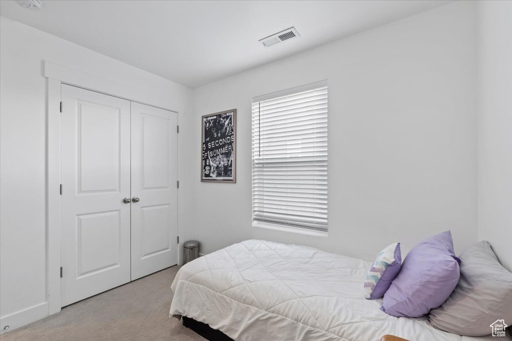 Bedroom featuring carpet and a closet