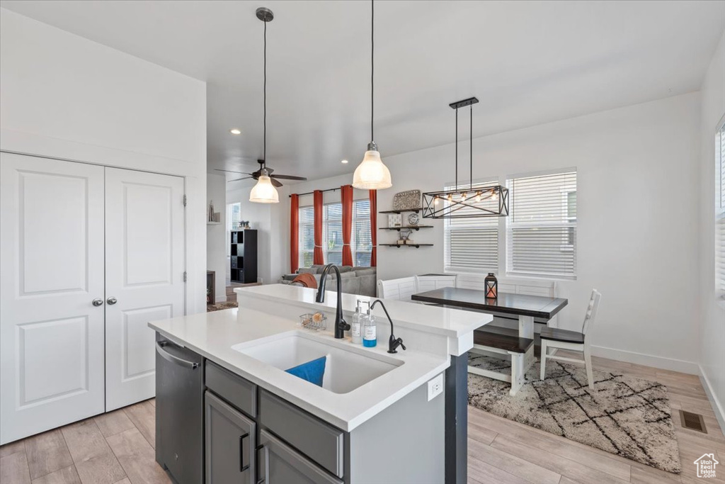 Kitchen featuring gray cabinetry, healthy amount of natural light, light countertops, dishwasher, and recessed lighting