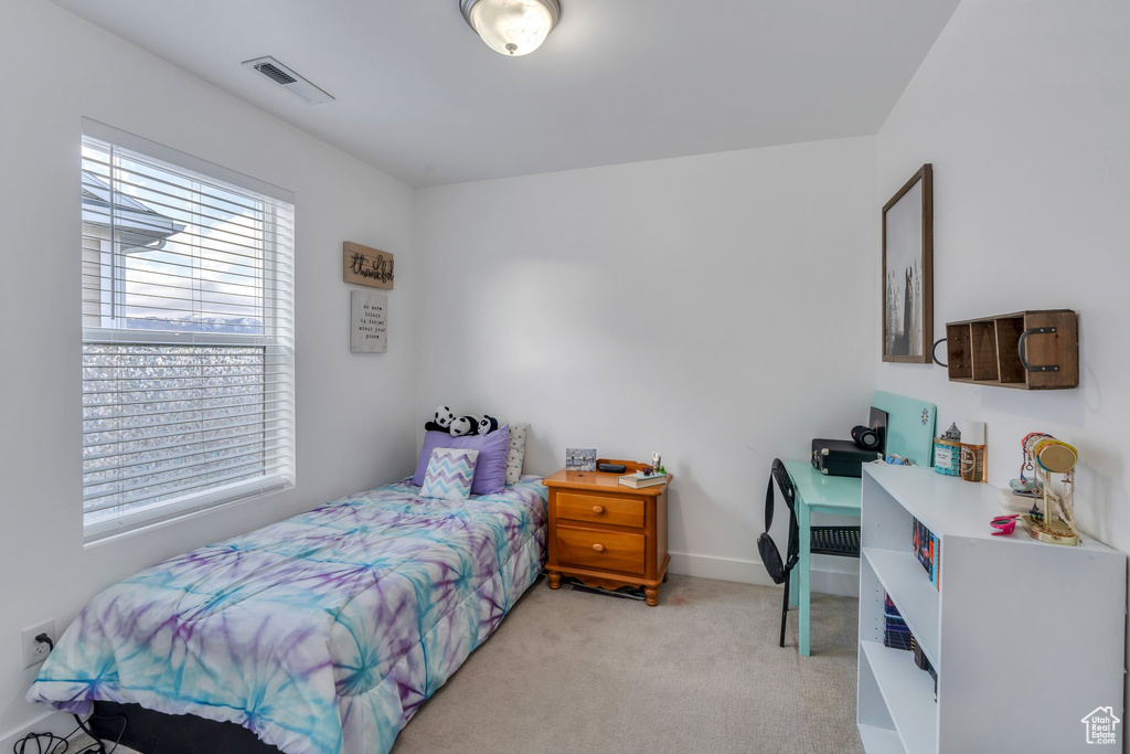 Bedroom with baseboards, light colored carpet, and visible vents