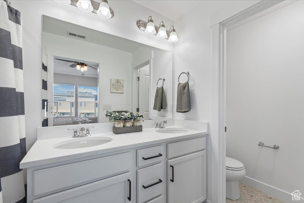Full bathroom with double vanity and a ceiling fan