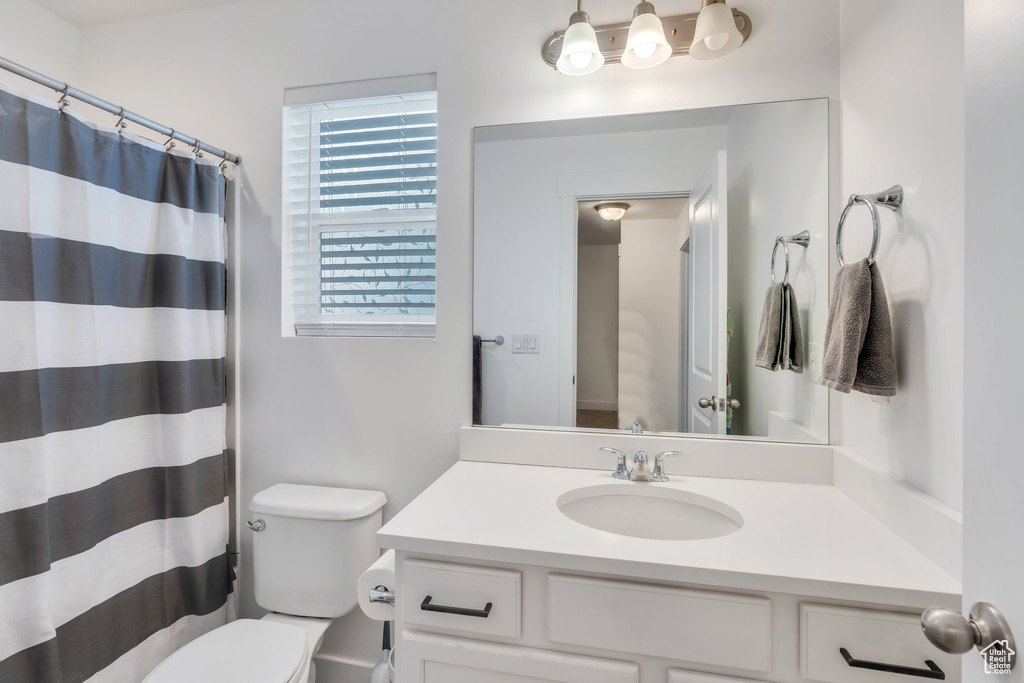 Full bathroom featuring toilet, a shower with curtain, and vanity