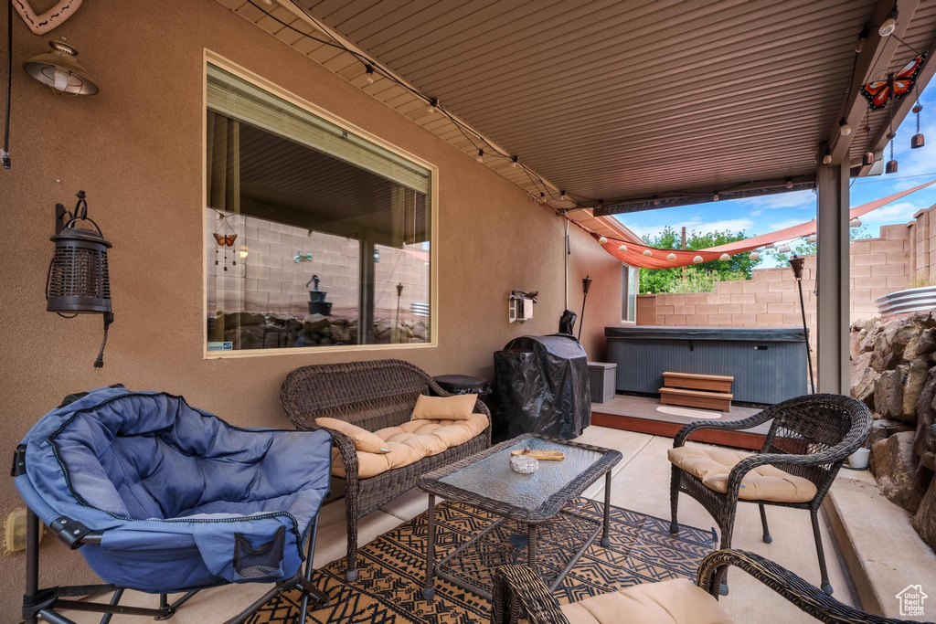 View of patio / terrace featuring a hot tub, fence, and an outdoor living space