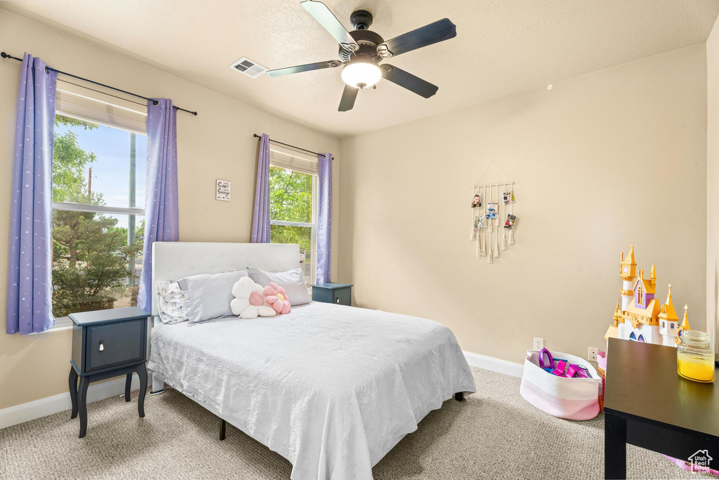 Bedroom with baseboards, ceiling fan, carpet floors, and visible vents