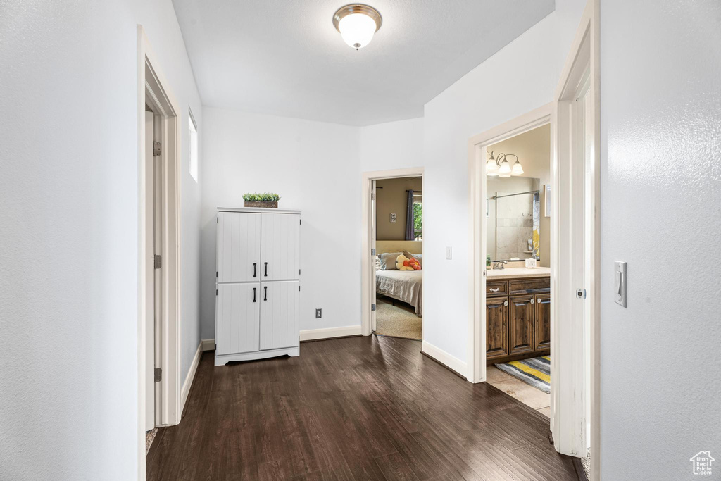 Corridor featuring baseboards and dark wood-style flooring