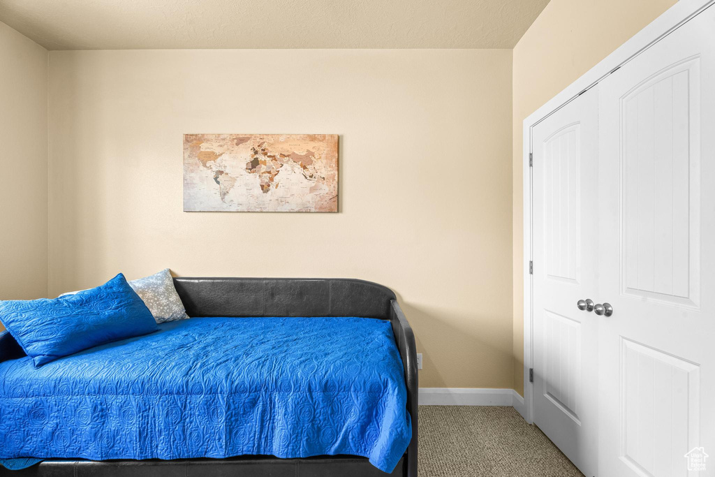 Bedroom featuring carpet flooring and baseboards