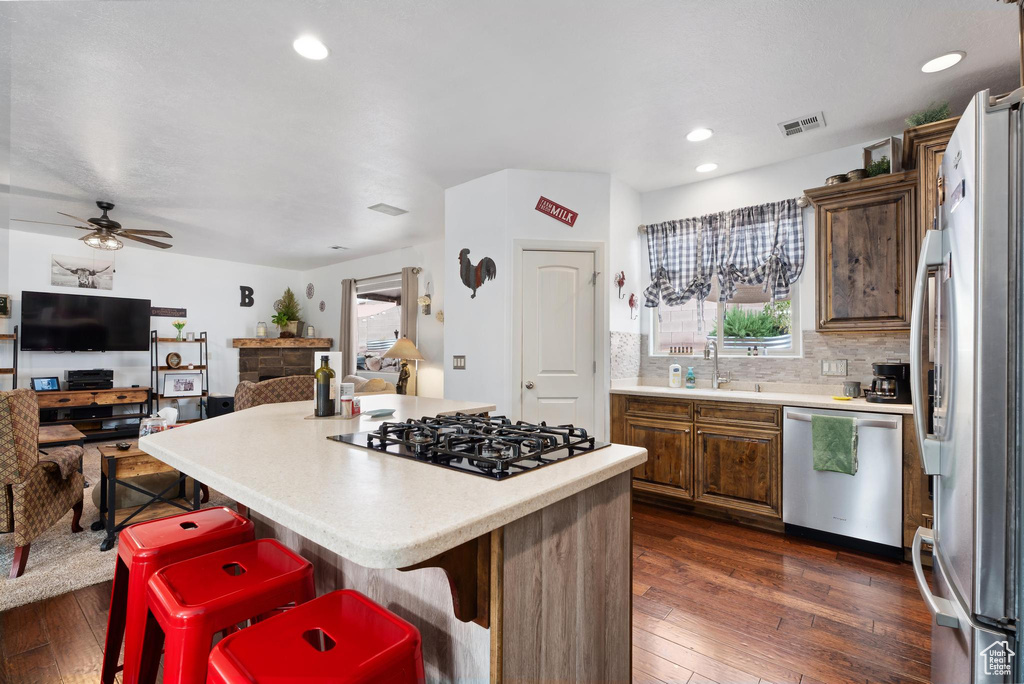 Kitchen featuring visible vents, dark wood-type flooring, light countertops, a center island, and stainless steel appliances