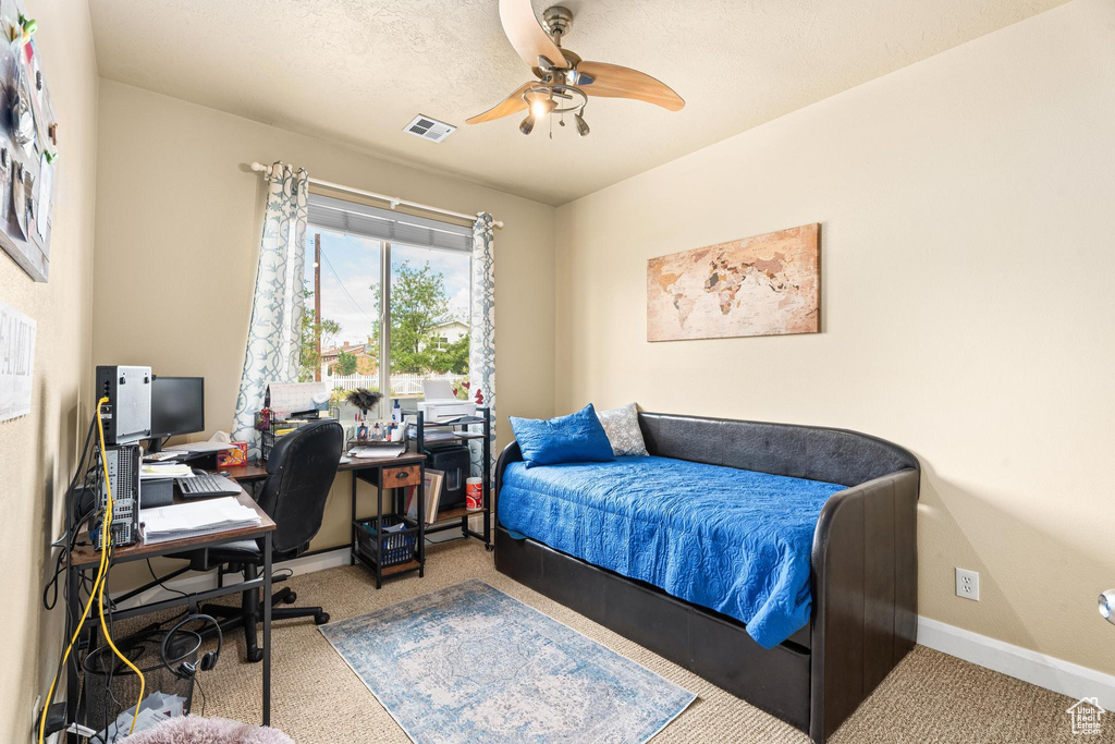 Carpeted bedroom featuring baseboards, visible vents, and ceiling fan