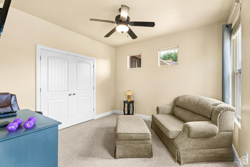 Sitting room with carpet floors, a ceiling fan, and baseboards