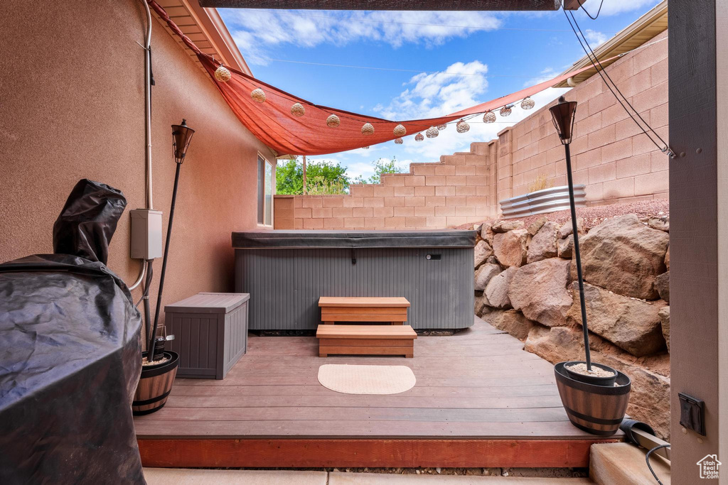 Wooden deck featuring a hot tub and a fenced backyard