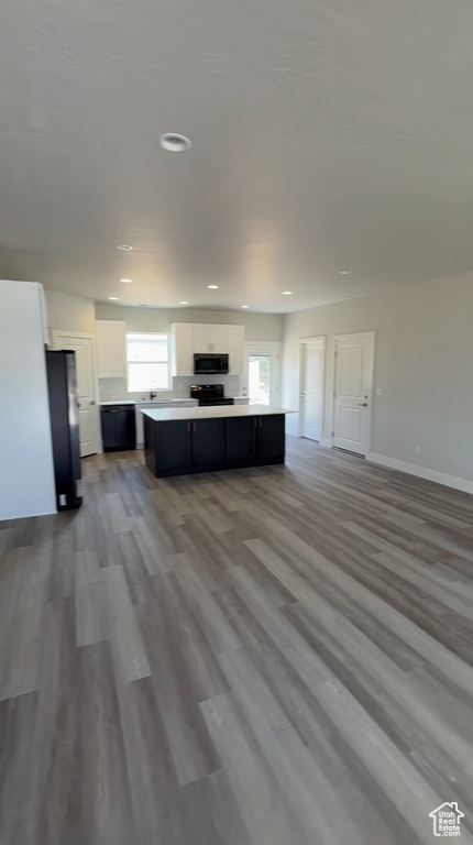 Living area featuring baseboards, recessed lighting, and wood finished floors