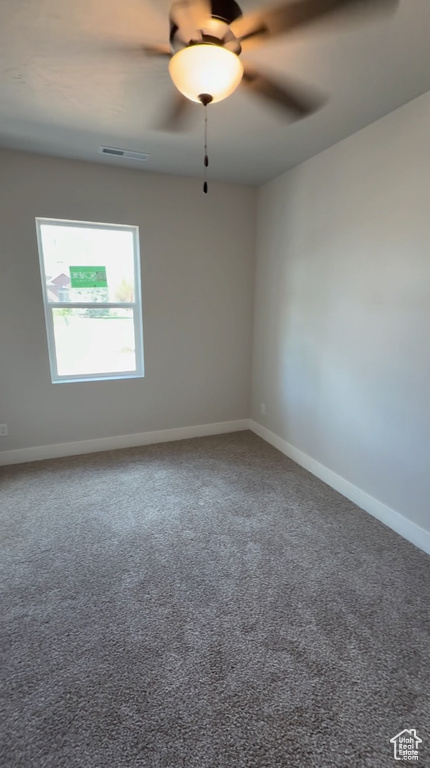 Empty room with baseboards, a ceiling fan, carpet flooring, and visible vents