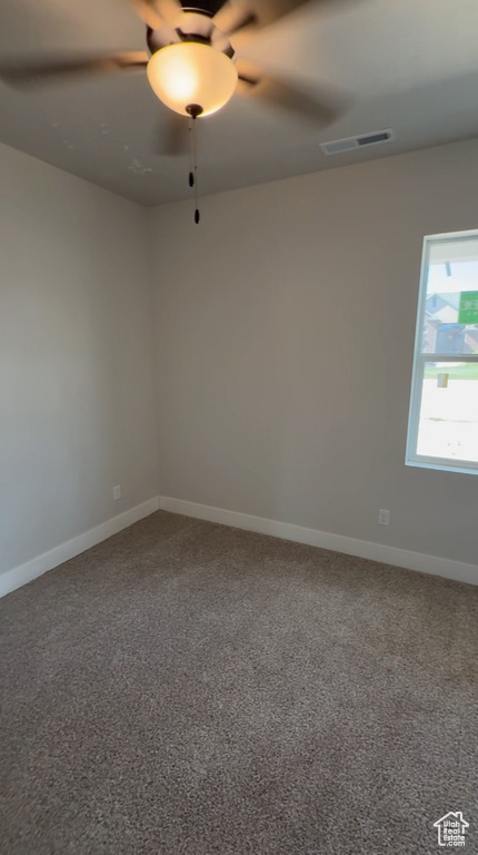 Carpeted spare room with a ceiling fan, baseboards, and visible vents