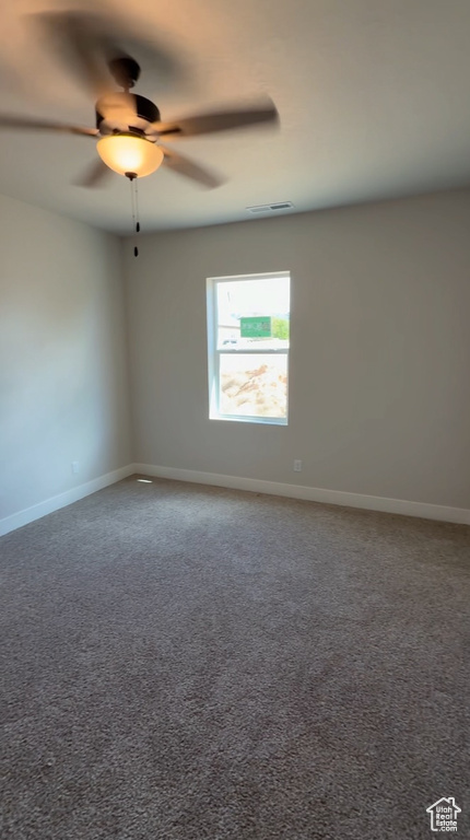 Carpeted spare room with baseboards, ceiling fan, and visible vents