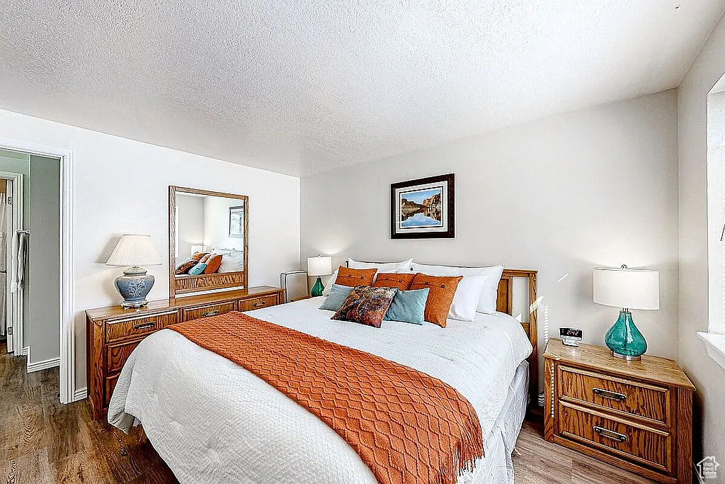 Bedroom featuring a textured ceiling and dark wood-type flooring