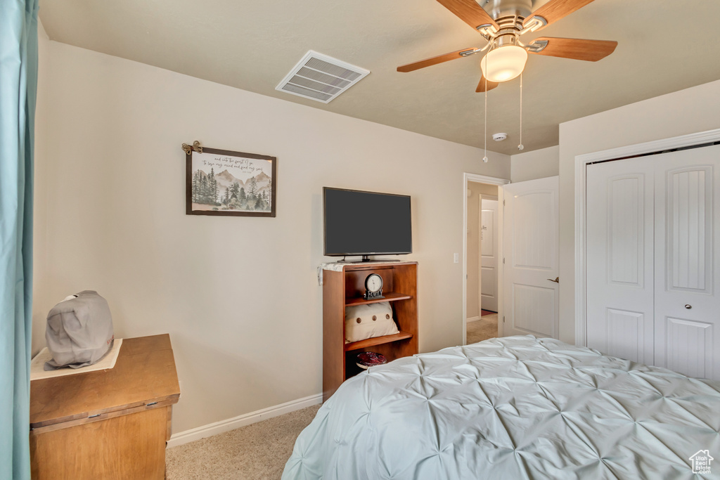 Carpeted bedroom featuring a ceiling fan, baseboards, visible vents, and a closet