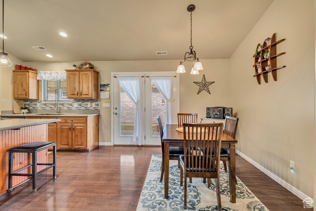 Dining area with baseboards, dark wood-type flooring, and visible vents