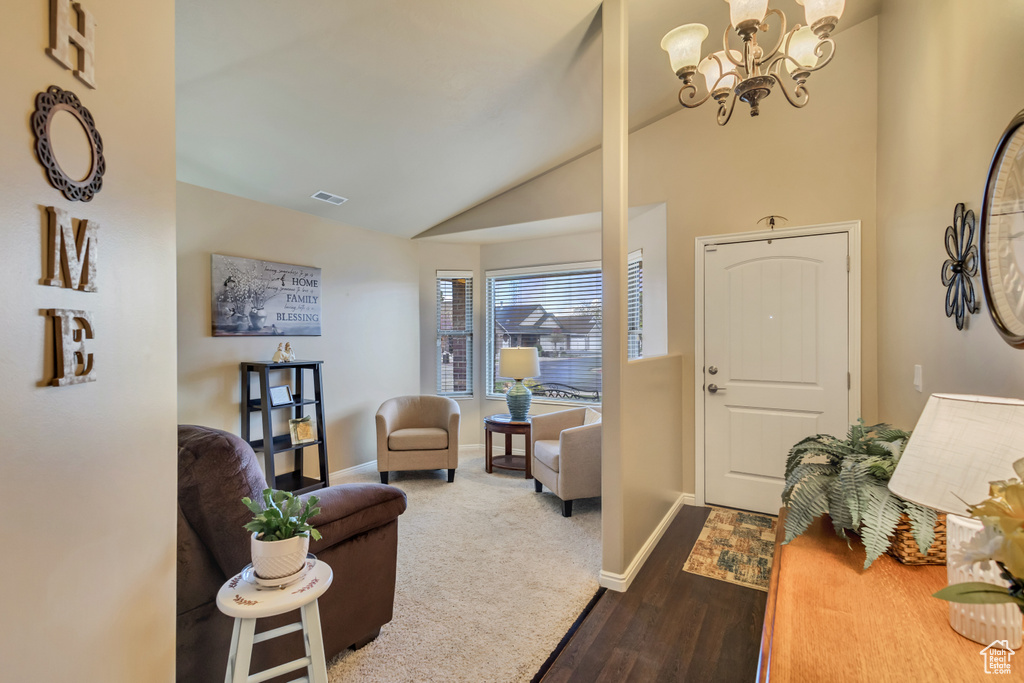 Foyer with visible vents, baseboards, dark wood-style floors, a chandelier, and lofted ceiling