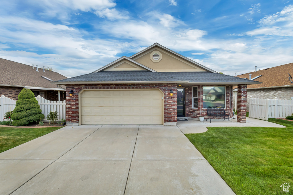 Ranch-style house with fence, an attached garage, driveway, and brick siding