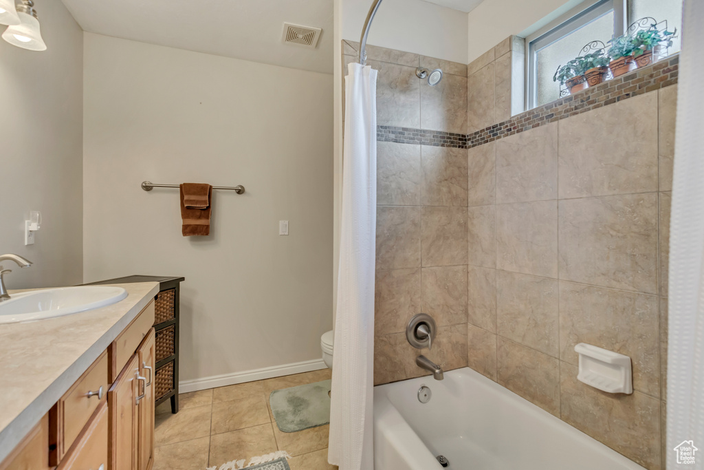 Bathroom featuring visible vents, shower / bath combo with shower curtain, tile patterned flooring, vanity, and toilet
