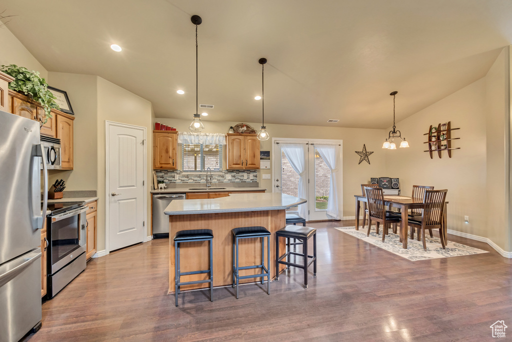 Kitchen featuring a sink, light countertops, stainless steel appliances, and dark wood finished floors