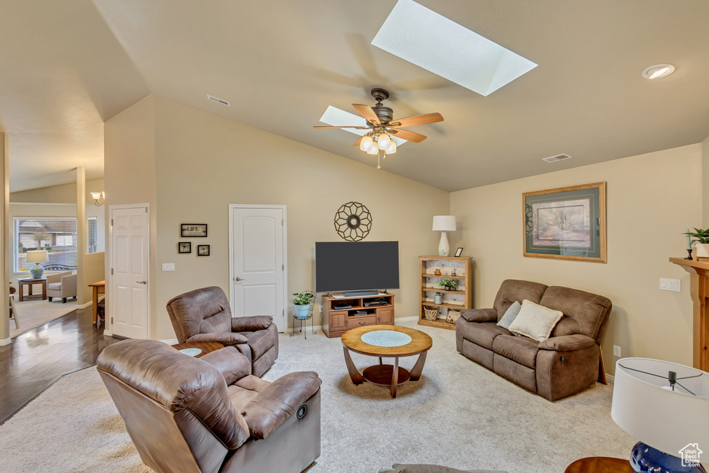 Living area with baseboards, ceiling fan, lofted ceiling with skylight, and visible vents