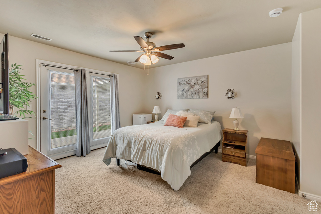 Bedroom with light colored carpet, access to exterior, a ceiling fan, baseboards, and visible vents