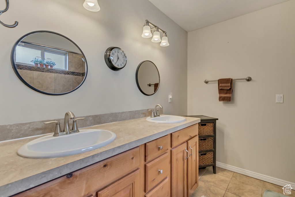 Full bath featuring a sink, tile patterned floors, baseboards, and double vanity
