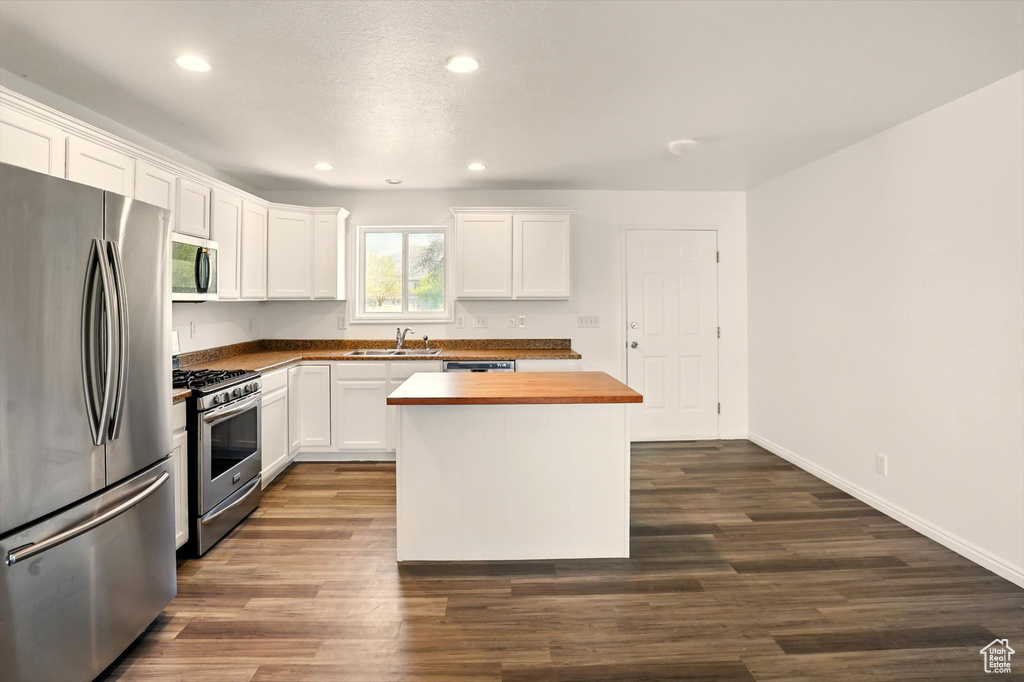 Kitchen featuring a sink, appliances with stainless steel finishes, wooden counters, and recessed lighting