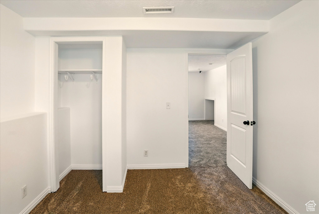 Unfurnished bedroom featuring visible vents, carpet flooring, baseboards, and a closet