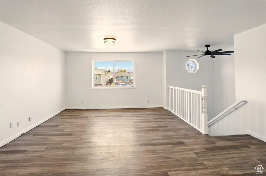 Spare room with baseboards, ceiling fan, and wood finished floors