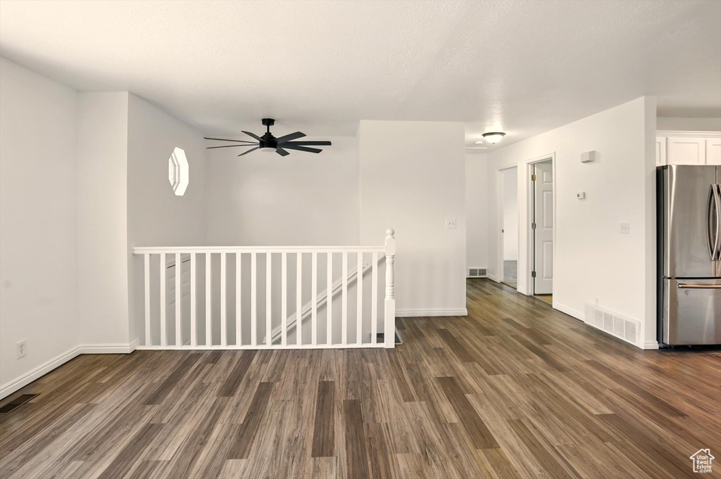 Interior space featuring visible vents, baseboards, and dark wood-type flooring