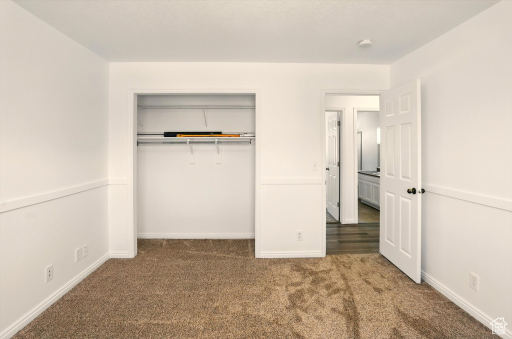 Unfurnished bedroom with a closet, baseboards, and carpet flooring
