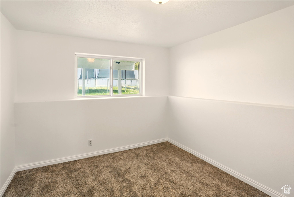 Carpeted empty room featuring baseboards