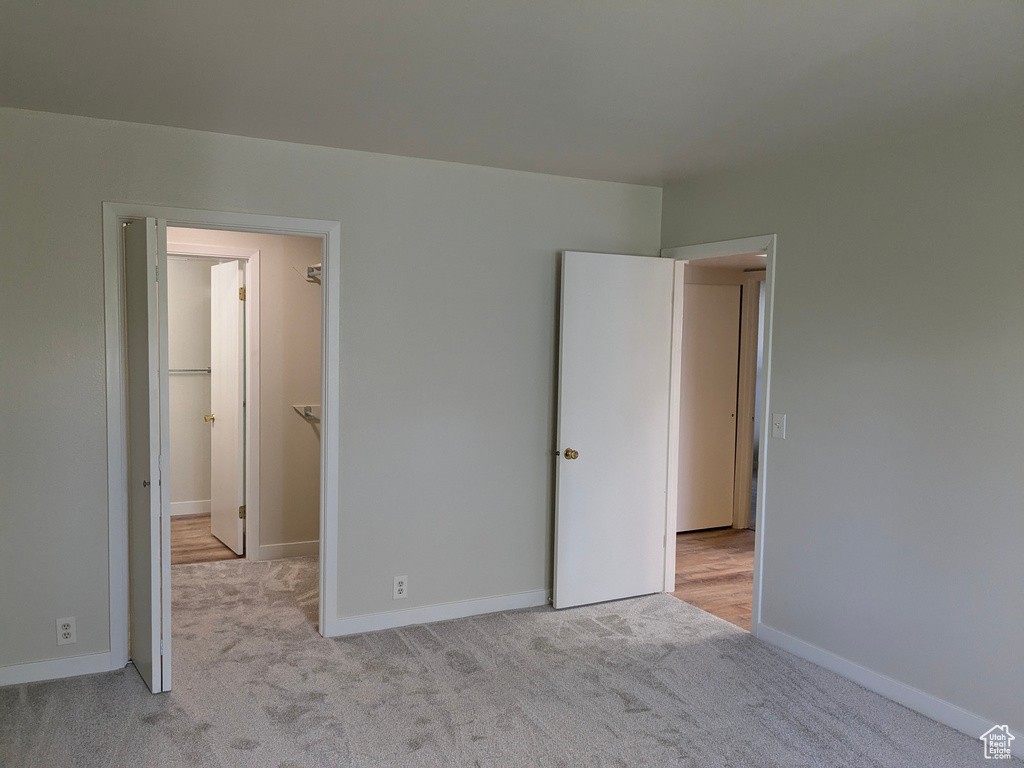 Unfurnished bedroom featuring baseboards, carpet flooring, and a spacious closet