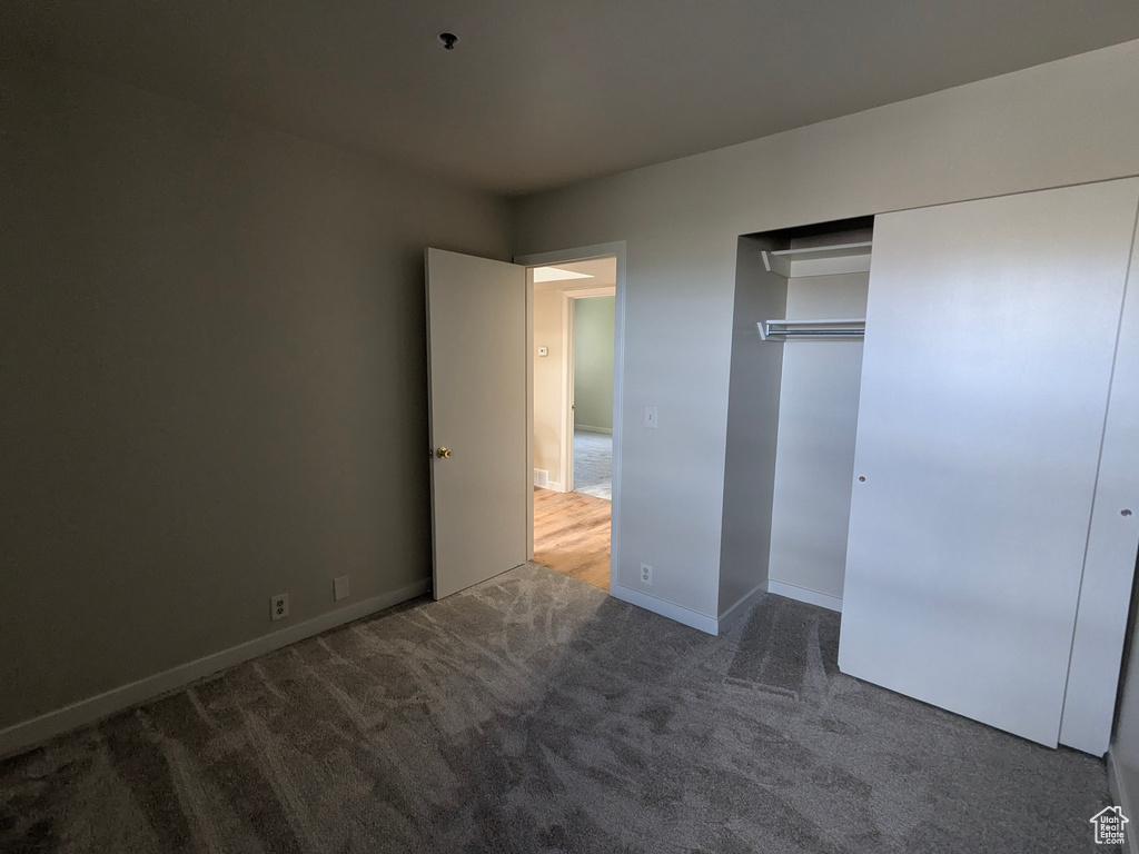 Unfurnished bedroom with baseboards, carpet, and a closet