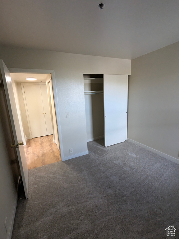 Unfurnished bedroom with carpet floors, baseboards, and a closet