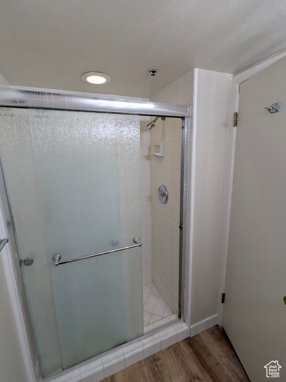 Bathroom featuring a stall shower, recessed lighting, and wood finished floors