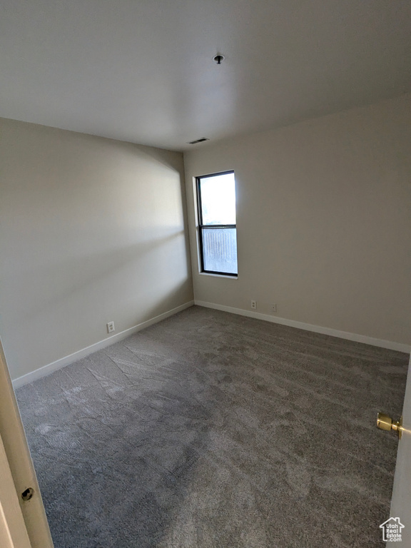 Carpeted empty room with baseboards and visible vents