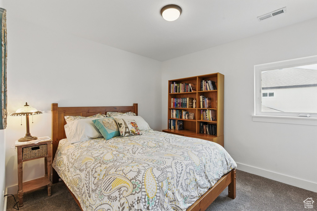 Bedroom featuring visible vents, baseboards, and dark carpet