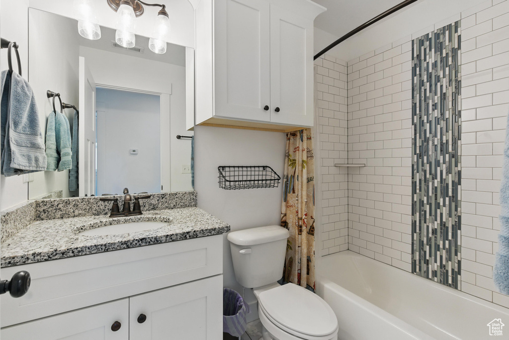 Bathroom featuring vanity, shower / bath combination with curtain, toilet, and visible vents