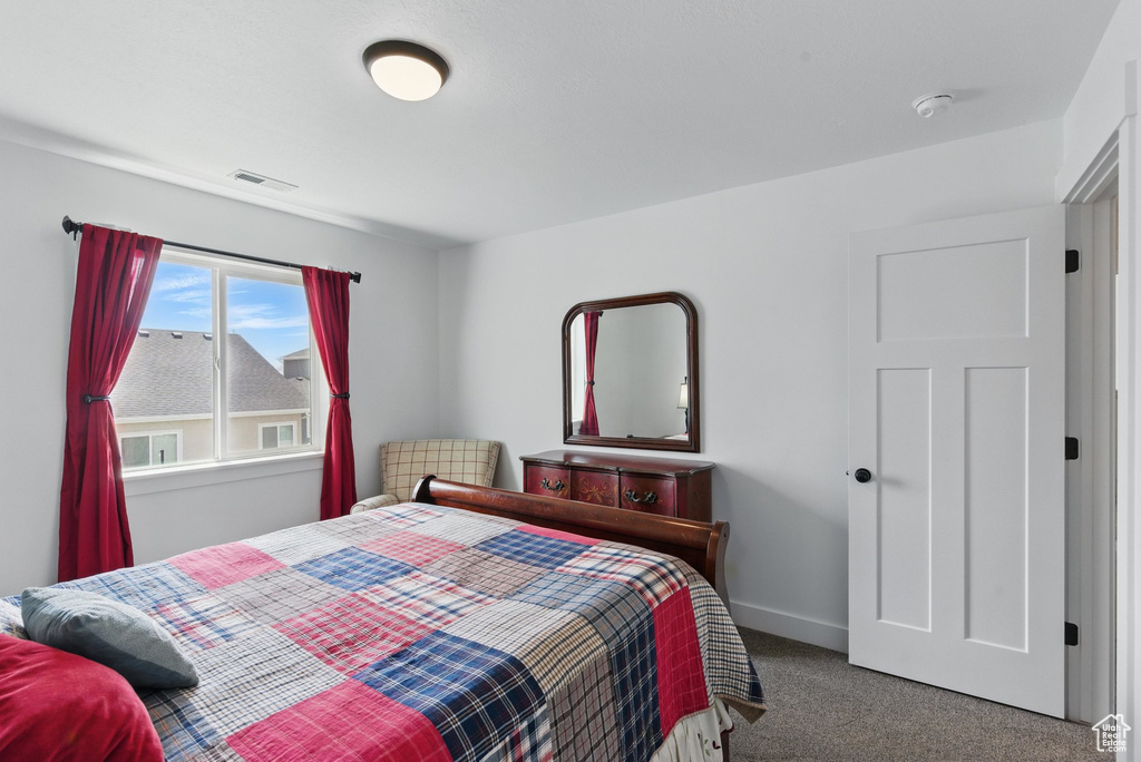 Carpeted bedroom with baseboards and visible vents