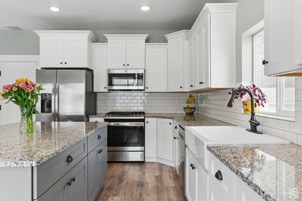 Kitchen with gray cabinets, white cabinetry, and stainless steel appliances