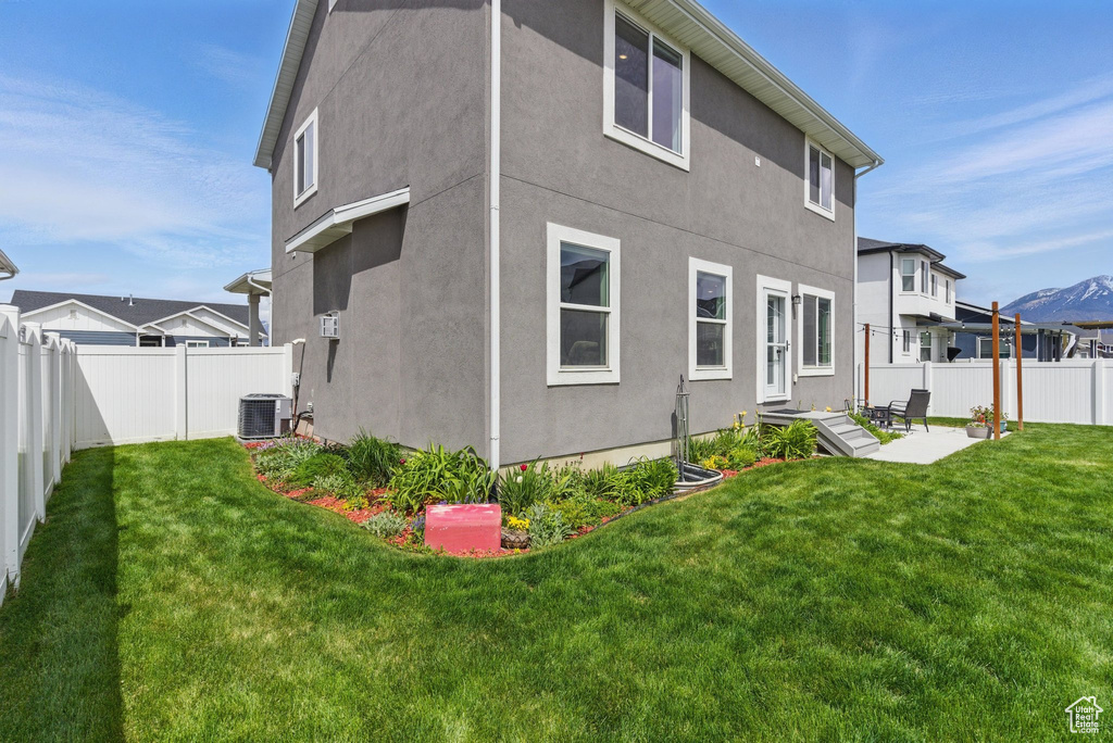 Back of house with a lawn, a patio, stucco siding, and a fenced backyard
