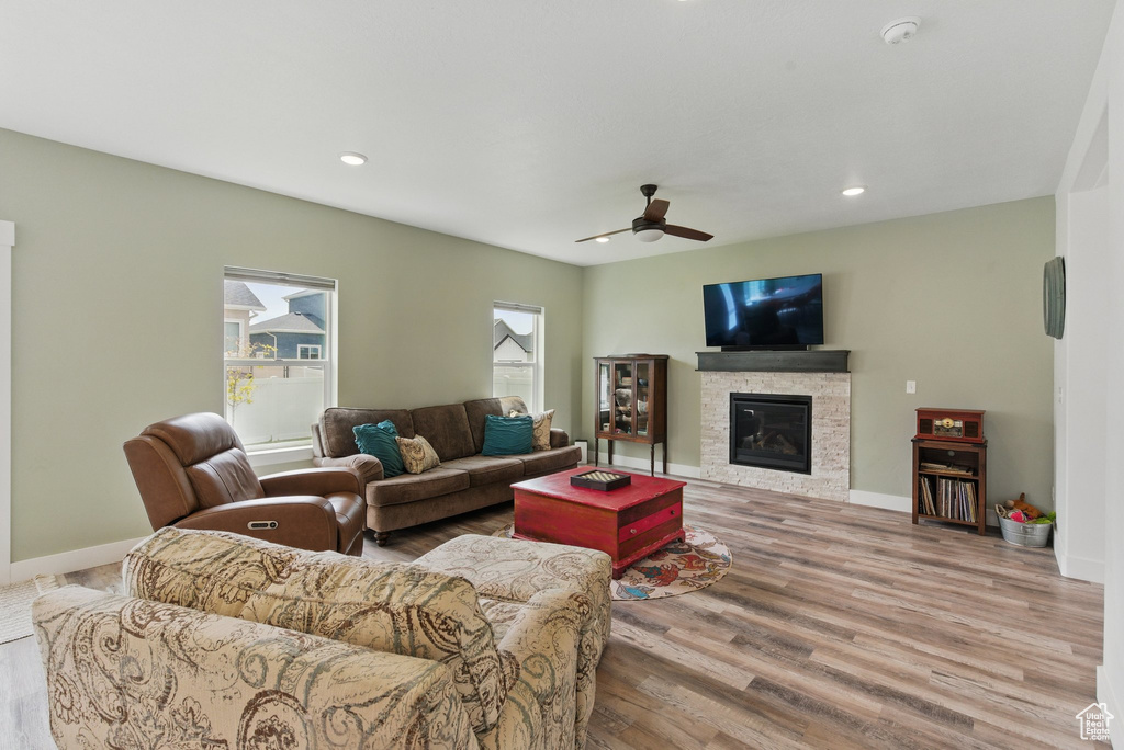 Living room with a fireplace, a ceiling fan, recessed lighting, and wood finished floors