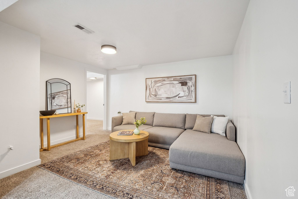 Carpeted living room featuring visible vents and baseboards