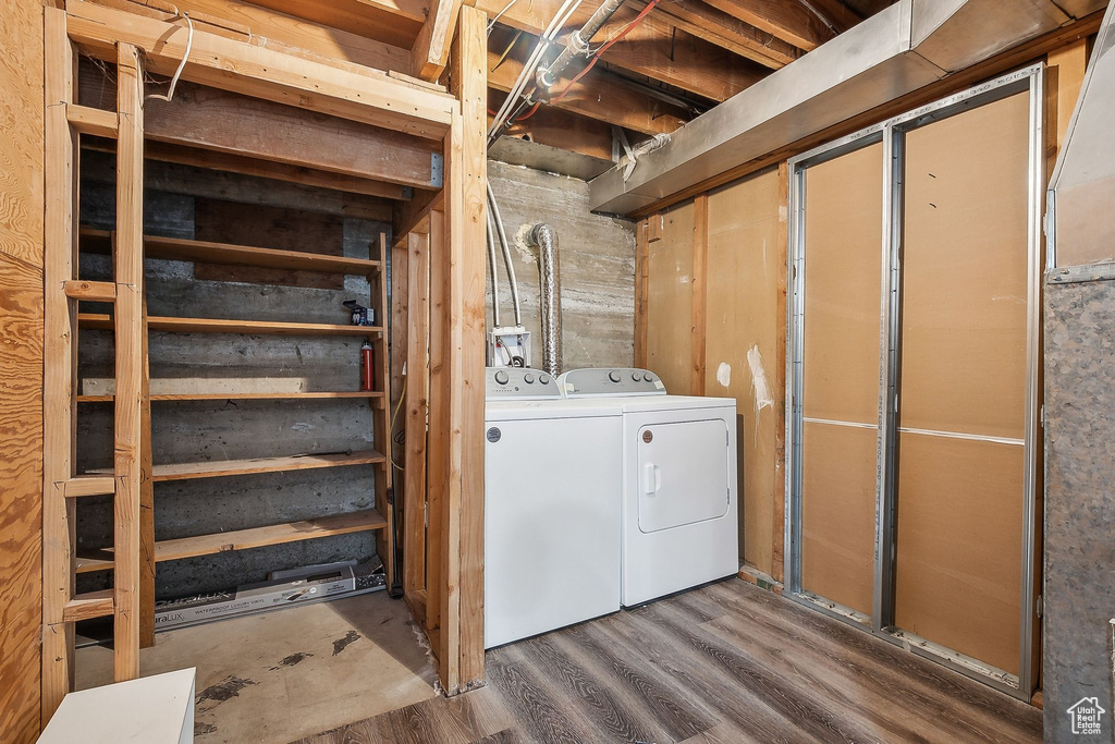 Washroom with separate washer and dryer, laundry area, and wood finished floors