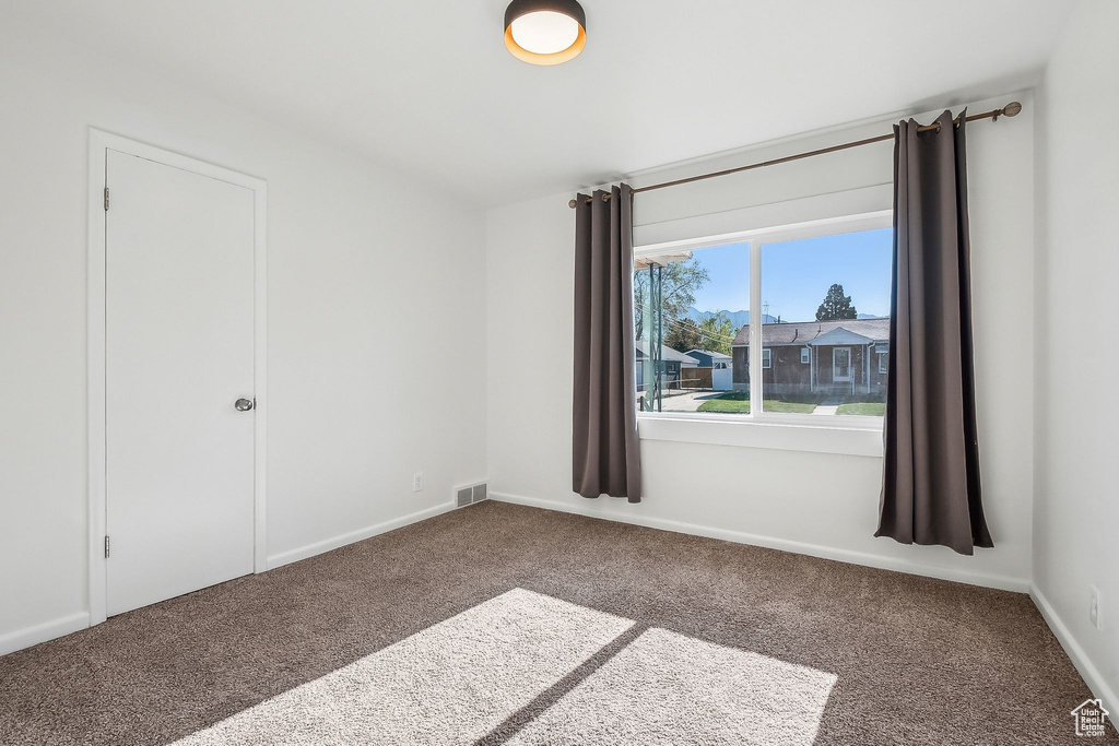 Carpeted spare room with baseboards and visible vents